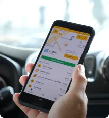 Hand holding a phone with the connected mobility app inside a car