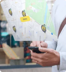 Hand holding a phone with a city map showing location pins